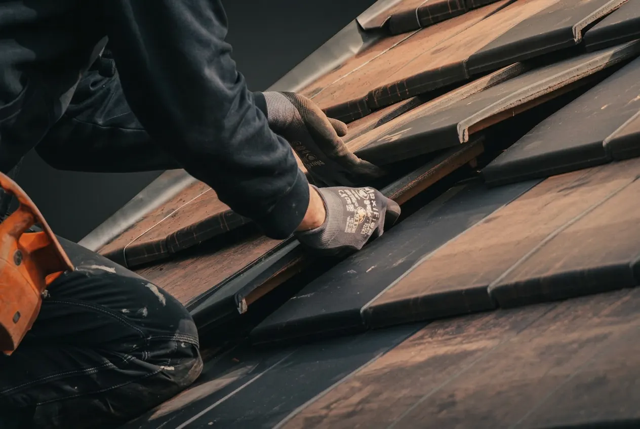 Detail van vakmanschap, handen die dakpannen plaatsen