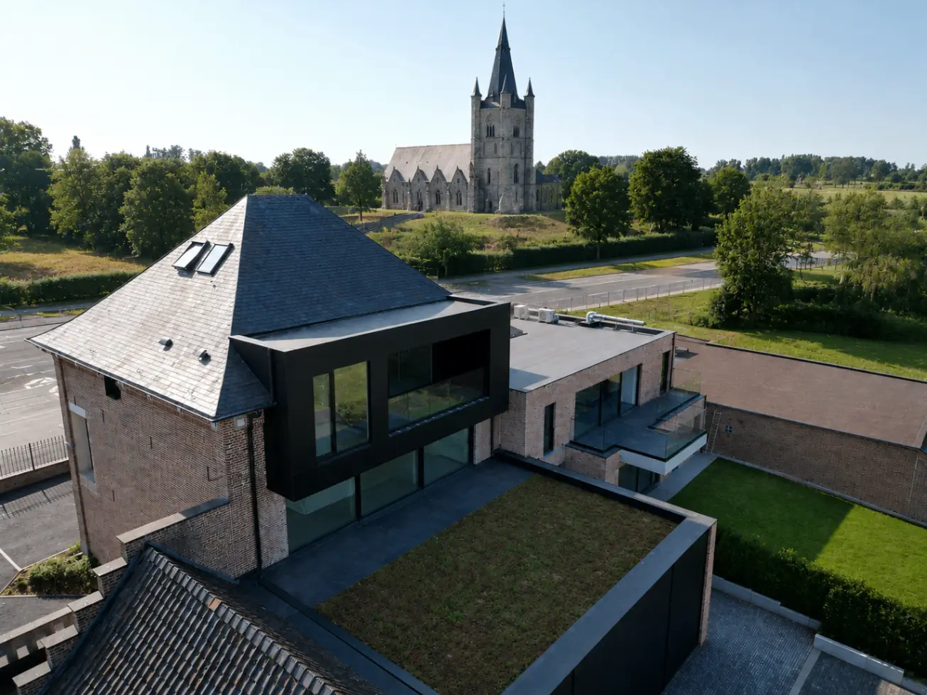 De Castel in dialoog met het omliggende landschap en zicht op de kerk van Pajottegem (Herne)