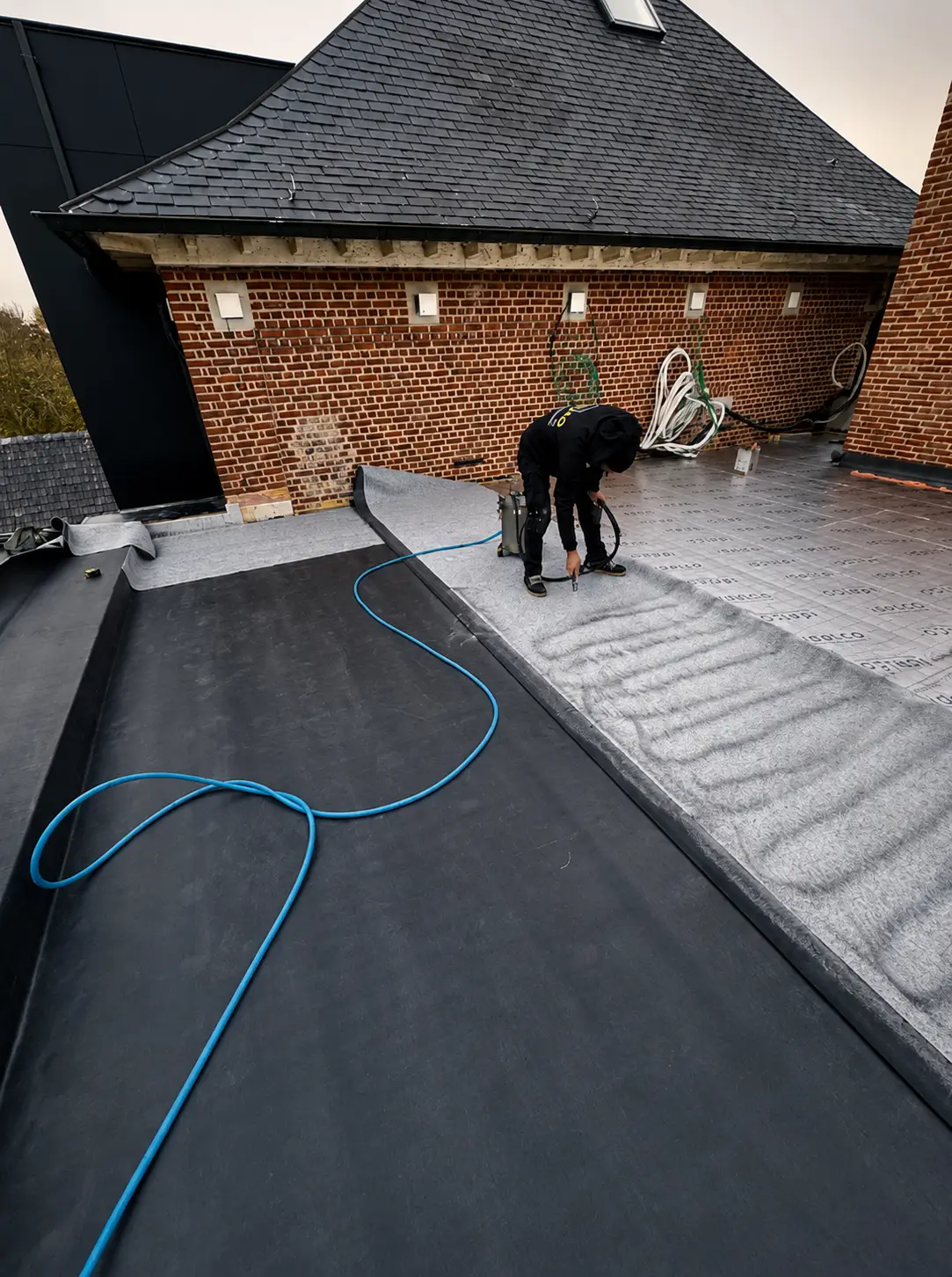 EPDM dakbedekking wordt verlijmd op het platte dak, De Castel